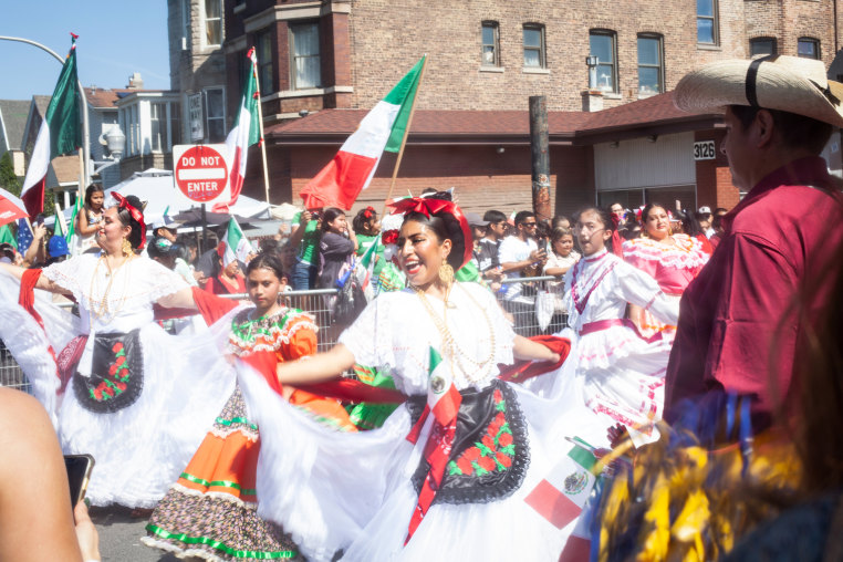 Women dance in a parade crowd