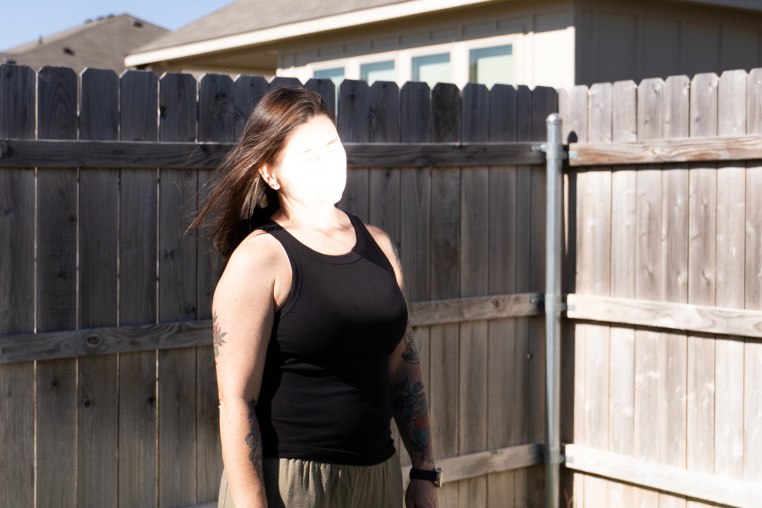 Jane Doe, face obscured by sunlight, in her backyard.