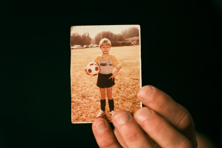 Chris Woods Sr. holds a childhood photo of himself.